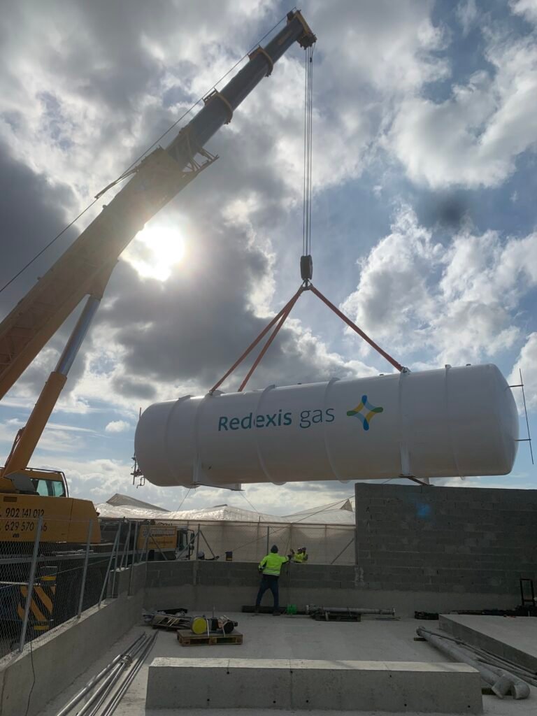Vista panorámica de una planta de almacenamiento de gas natural licuado (GNL) con tanques criogénicos verticales y sistemas de regasificación.